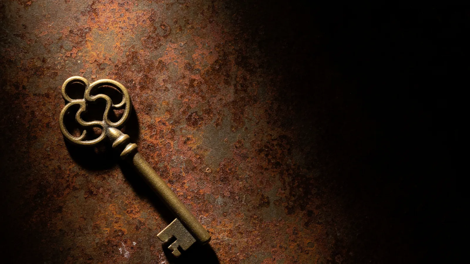 Llave de latón sobre una superficie de metal oxidado, cerrajería en Burjassot